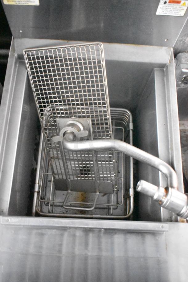 Interior view of a Cruising Kitchens food trailer featuring a commercial-grade deep fryer with wire baskets and a stainless steel finish.