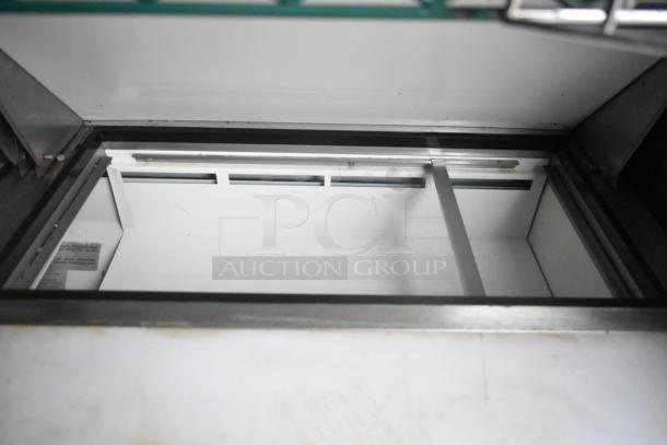 Interior view of a Cruising Kitchens food trailer with shiny metal framing and white paneling.