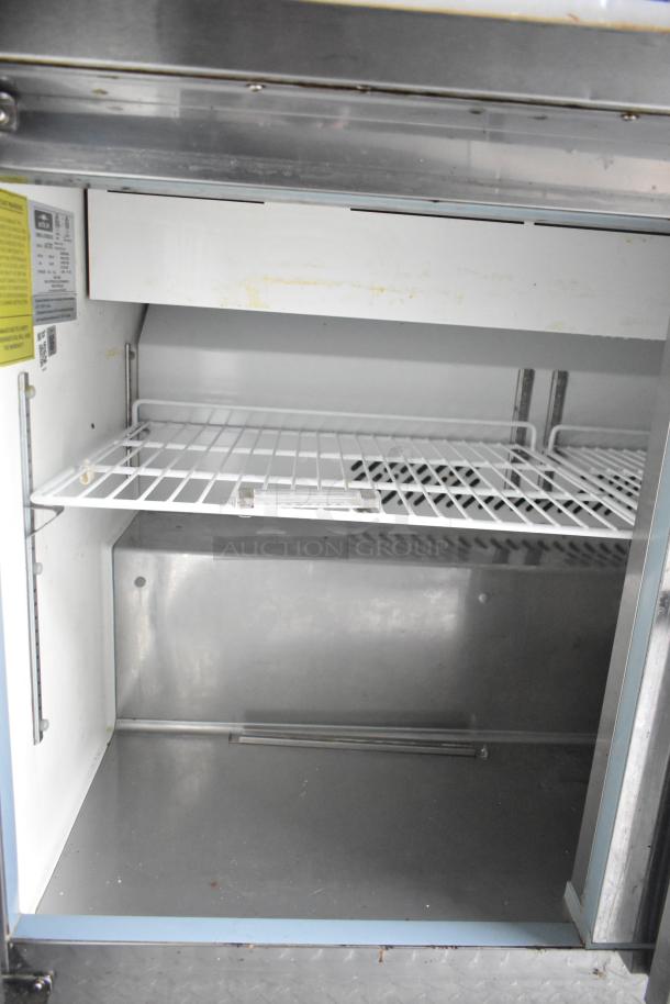 Interior view of Cruising Kitchens food trailer showing a commercial-grade refrigerator with wire shelf, clear title ready.