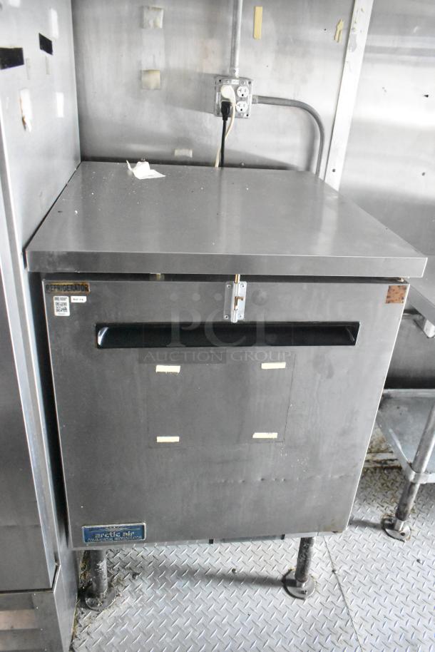 Cruising Kitchens 24' food trailer with Arctic Air commercial refrigerator. Stainless steel finish, ready for operation.