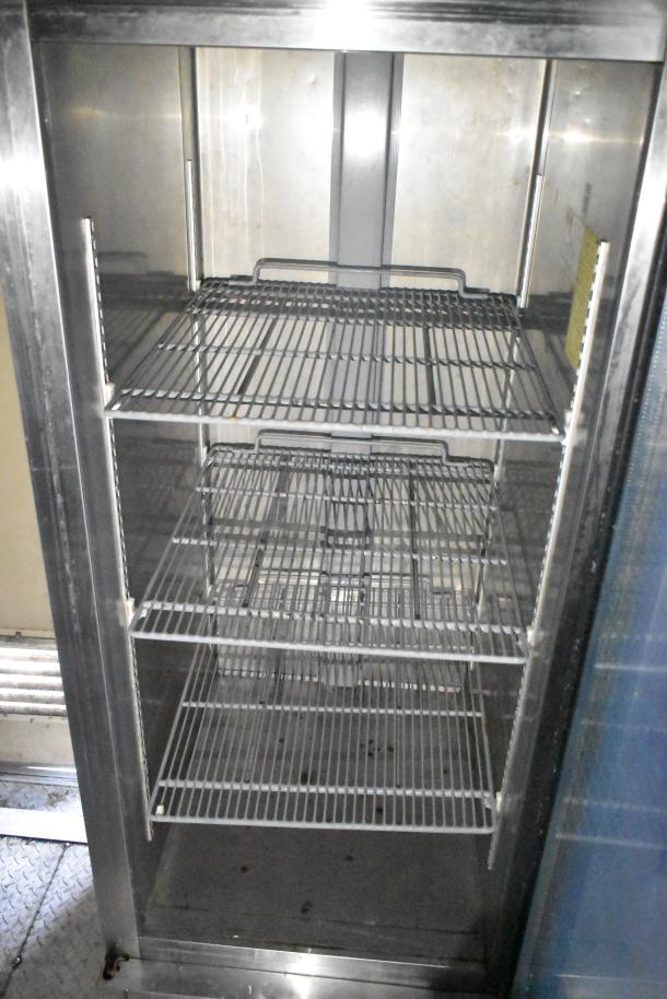 Interior view of a Cruising Kitchens 24' food trailer with commercial-grade metal racks. Clean and ready for use.