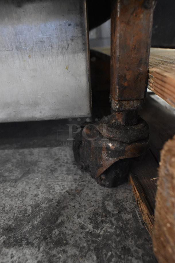 Henny Penny 600 stainless steel pressure fryer on commercial casters, visible signs of wear. Natural gas, 80,000 BTU.