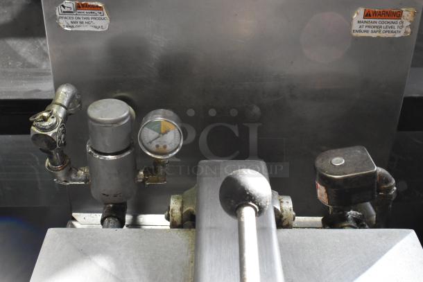 Henny Penny 600 Stainless Steel Pressure Fryer controls and gauges shown. Warning labels visible on metal surface.