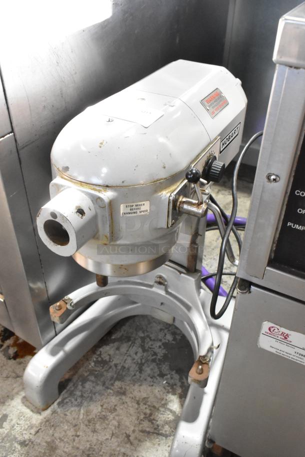 Hobart A120T 12 Quart Planetary Dough Mixer, metal, 115V, 1 phase. Visible wear, labels indicate speed warnings.