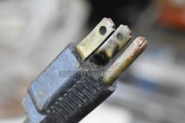 Close-up of a worn electrical plug for a Hobart A120T commercial dough mixer. Three-prong metal connector visible.