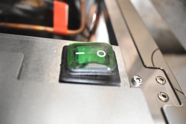 Green power switch on the 2025 Manitowoc RFP0620A-161 commercial flake ice machine, stainless steel housing.