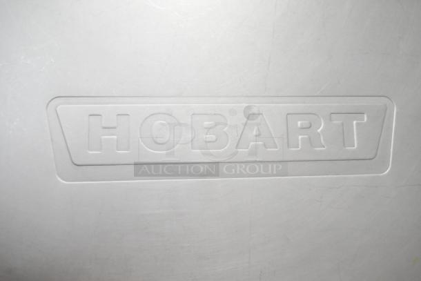 Hobart branding on metal commercial floor-style meat saw, highlighting manufacturer's logo.