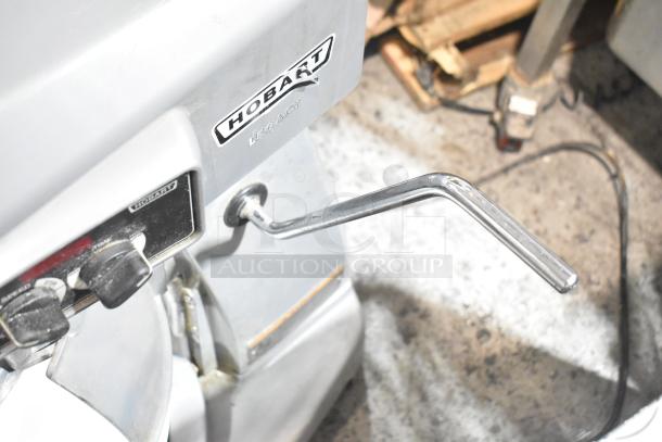 Hobart Legacy HL200 commercial 20-quart mixer, metal construction, with mixing bowl and dough hook. Visible controls and branding.