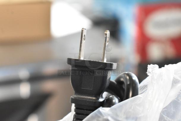 A power plug for a 2025 Avantco 177IC18DB stainless steel induction range is pictured partially wrapped in plastic.
