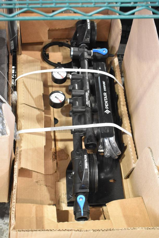 Brand new Everpure EV9328-06 High Flow CSR Triple-MC2 water filtration system in box, with visible pre-filter, gauges, and labels.
