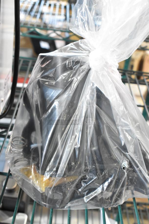 Brand new Bossen ET-99SU metal countertop cup sealing machine, 110/120 volts, 1 phase, in plastic wrap, scratches visible.