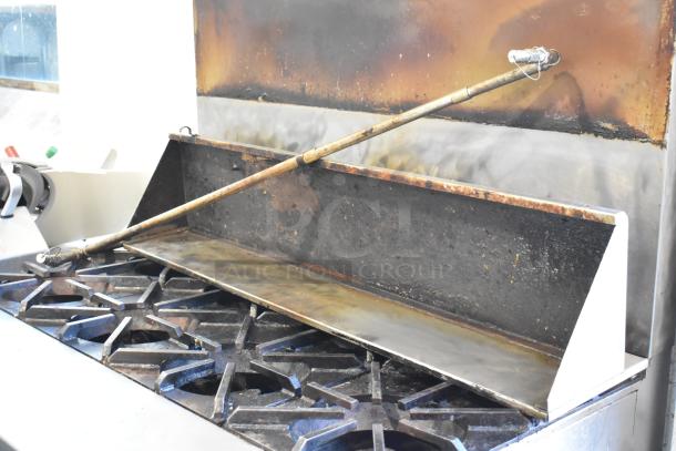 Southbend stainless steel commercial 8 burner range with oven, shows signs of use, on commercial casters.