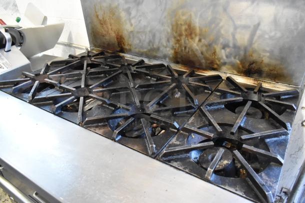 Southbend Stainless Steel Commercial 8 Burner Range with Oven, visible wear, on commercial casters.