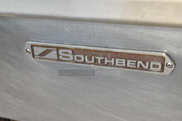 Southbend logo on stainless steel surface of commercial 8 burner range with oven, showing slight wear.