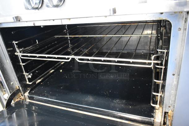 Southbend stainless steel 8 burner range's oven interior, showing two racks, moderate use condition, on commercial casters.