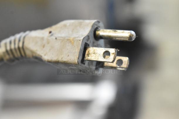 Close-up of a used plug for the Bizerba GSP HD meat slicer, showing a 3-prong configuration, indicating usage wear.