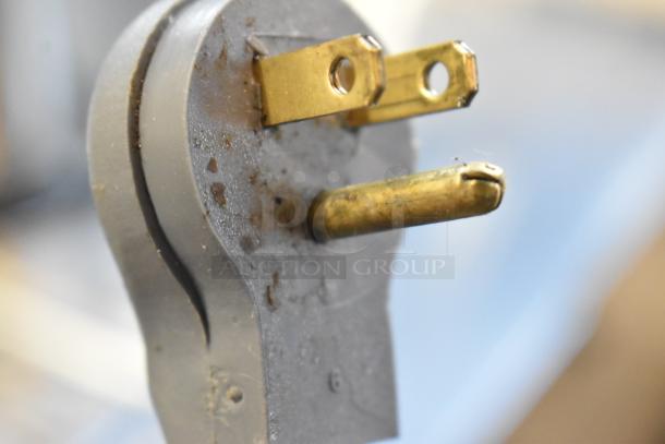 Plug of a metal bug zapper, 120 volts, 1 phase; features signs of wear with visible dirt and scuffs on the surface.