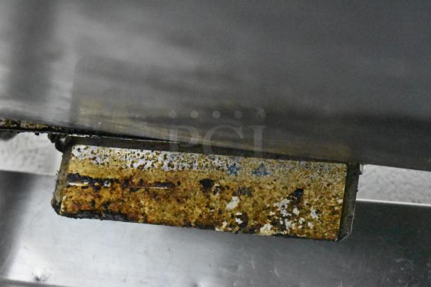 Garland Stainless Steel Commercial Gas 4-Burner Range, visible rust and wear, needs cleaning, ideal for high-volume kitchens.