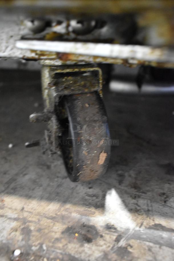 Close-up of a caster wheel on the 2024 Continental SW48N18M stainless steel sandwich prep table, showing wear and rust.