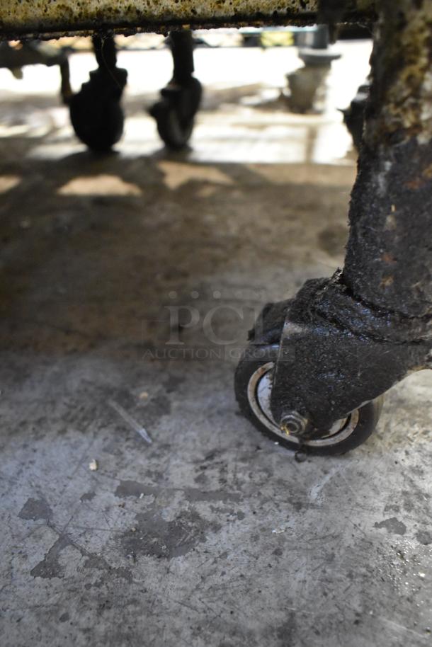 Close-up of a caster wheel on a 2018 Pitco Frialator SG14 commercial fryer, showing signs of wear.