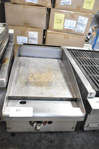 Stainless steel commercial countertop gas griddle, flat top, used condition, visible control knob, slight surface wear.