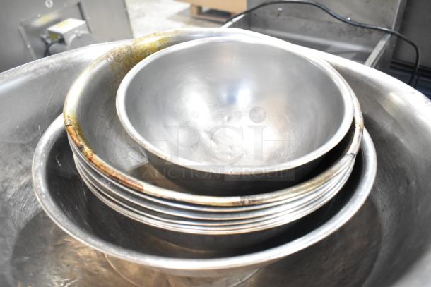 Lot of metal baking pans and bowls, various sizes, used condition, some discoloration, suitable for kitchen use.