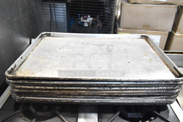 Stack of vintage metal baking pans showing wear and patina, part of a mixed auction lot.