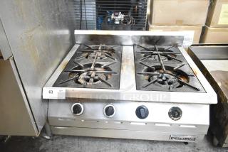 Garland Stainless Steel Commercial Gas 4 Burner Range in used condition, featuring sturdy cast-iron grates and manual controls.