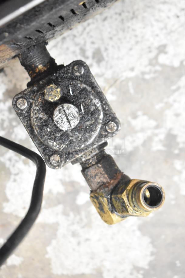 Stainless steel gas charbroiler grill valve, showing signs of rust and wear, essential for commercial kitchen use.