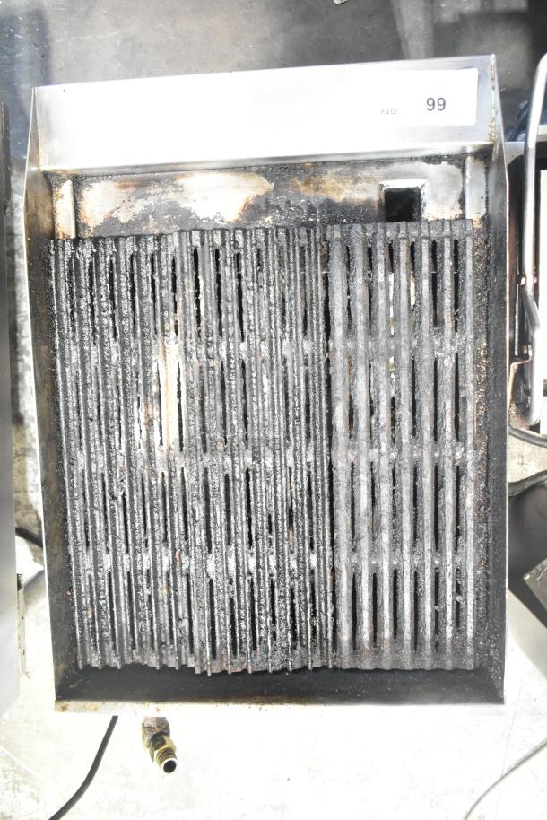 Stainless steel countertop gas charbroiler grill, commercial-grade, used condition, visible heat and grease marks.