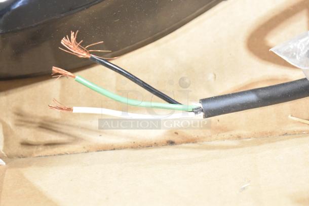 Close-up of exposed electrical wires from a light fixture, showing copper strands in black, green, and white cables.