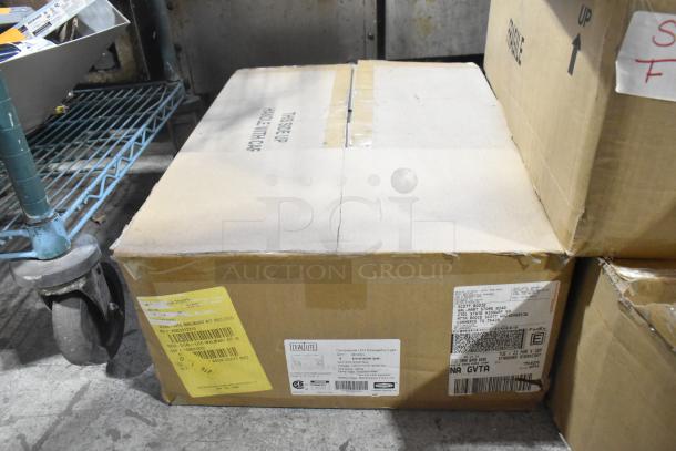 12 boxes of Dual Lite EVHCEZP LED emergency lights, new condition, labeled for commercial use.