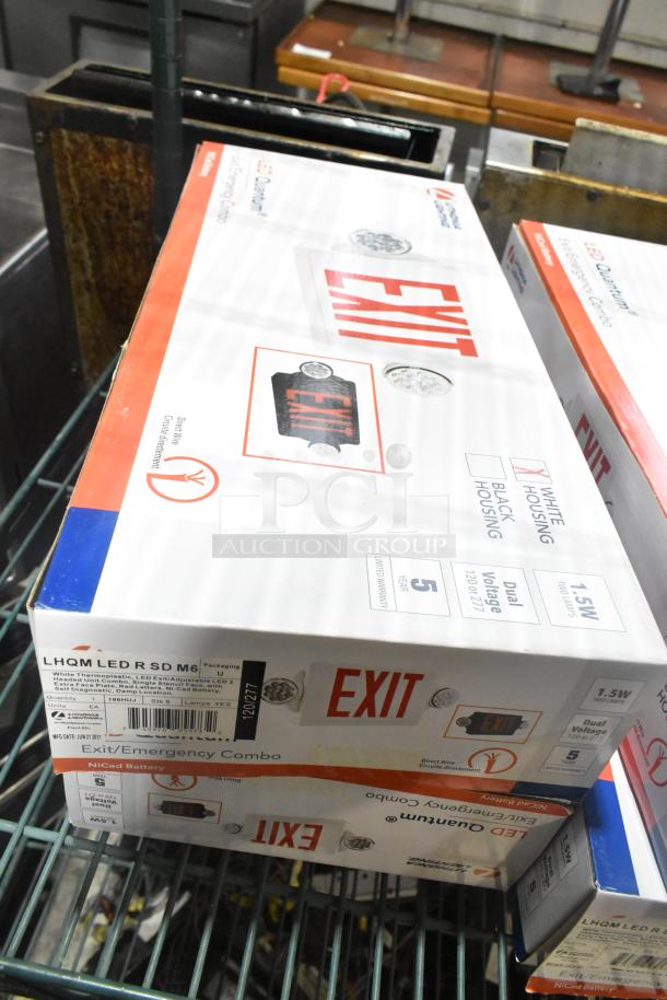 Seven new Lithonia Lighting LED exit signs, model LHQM LED R SD M6, in original packaging, featuring dual voltage and NiCad battery.