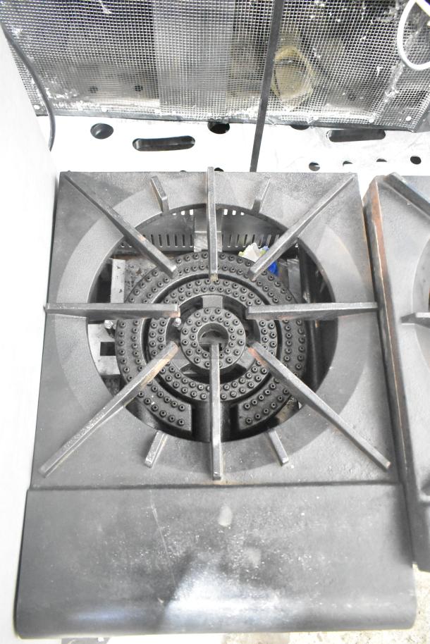 Stainless steel commercial gas-powered single burner stock pot range, heavy-duty design, in good condition.