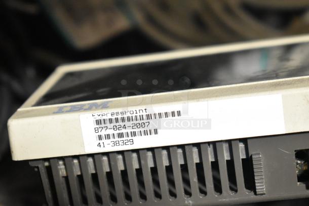 IBM device with visible label showing "877-024-2007" and "41-38329," part of a mixed pallet lot including wire spools.