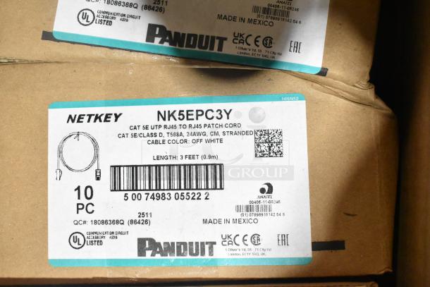 18 brand new boxes containing Panduit Netkey NK5EPC3Y patch cords and NK4FWHY faceplates. Labels indicate UL and CE certification, made in Mexico.