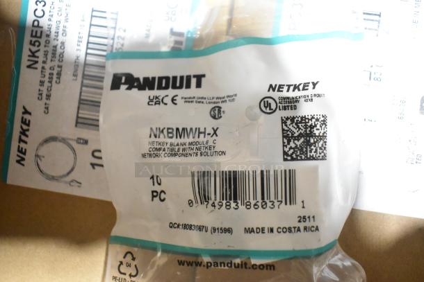 18 brand new Panduit Netkey items including NK5EPC3Y patch cords and NK4FWHY faceplates. Tags indicate model and specs.