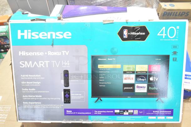 Hisense 40H4030F4 40" Smart TV in original box. Features Full HD, Dolby Audio, Roku TV. Box shows model and specs.