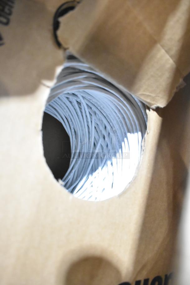 Box of coiled GenSpeed 5e Series cable, brand new condition, visible markings, ready for auction.