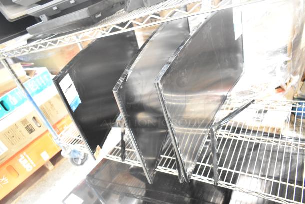 Three computer monitors on metal shelf, including Samsung C27F396FHN. Curved screens, black finish, good condition.