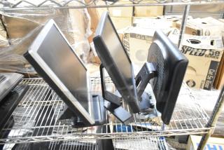 Three computer monitors displayed on a shelf, including Dell and HP models, in used condition.