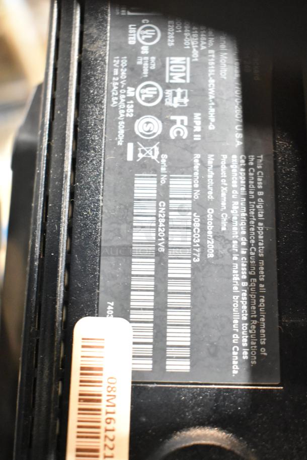 Alt text: Close-up of label on a computer monitor showing model and certification details. Part of a lot including Dell and HP monitors.