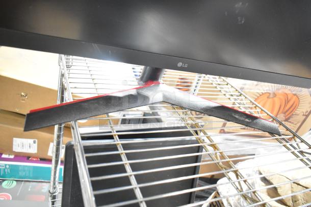 Four computer monitors including Samsung C32R500FHN and LG, on metal shelving. LG monitor stand visible.