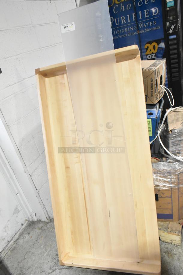 Clear poly panel and wooden butcher block tabletop. Includes auction tag "102 QTY UNX." Sold as two items per bid.