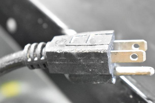 Close-up of a power plug with three metal prongs attached to a Vulcan VC6GE-SEFFCAM5 commercial convection oven.
