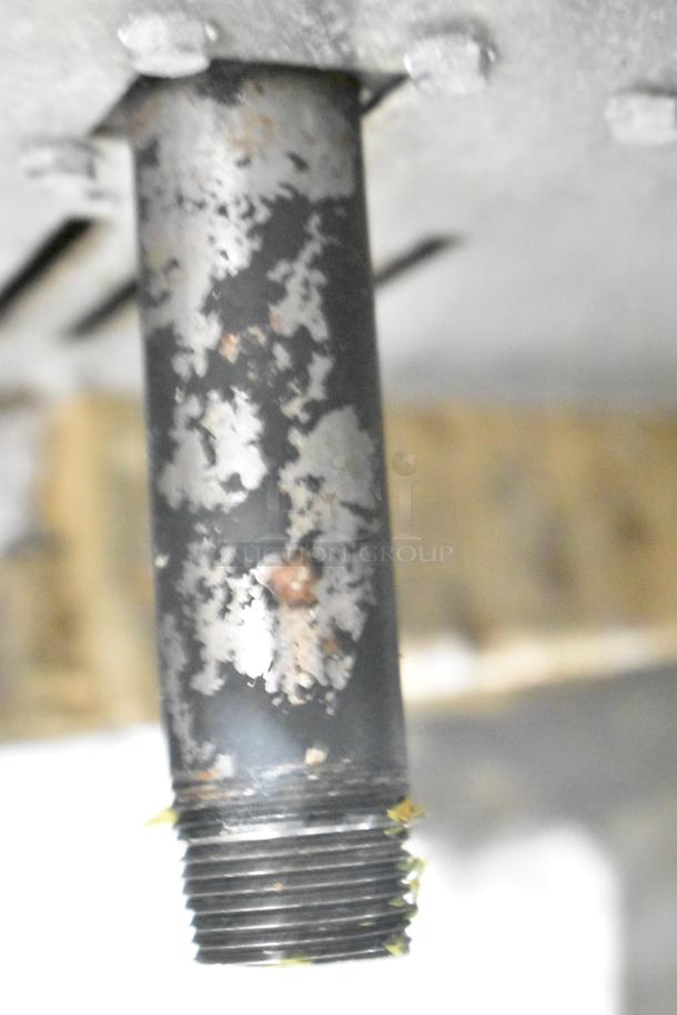 Close-up of a metal pipe with visible rust and wear on a larger device. Pipe threading is shown. Context of usage unknown.