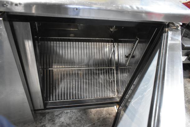 Turbo Air stainless steel commercial 3-door undercounter cooler, open door view. Features wire shelves, 115 volts, 1 phase.