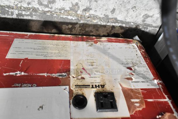 AHT Metal Commercial Floor Freezer Merchandiser label, visible wear, model details partially obscured, on commercial casters.