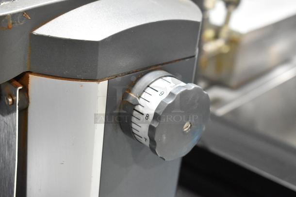 Mahlkonig Tanzania Grau espresso bean grinder, metal finish, no hopper, adjustable grind setting knob shown, 120V, 1 phase.