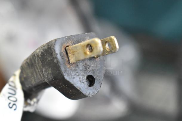 Close-up of a plug from an APW Wyott CW-2A food warmer, showing slight wear and metal prongs.